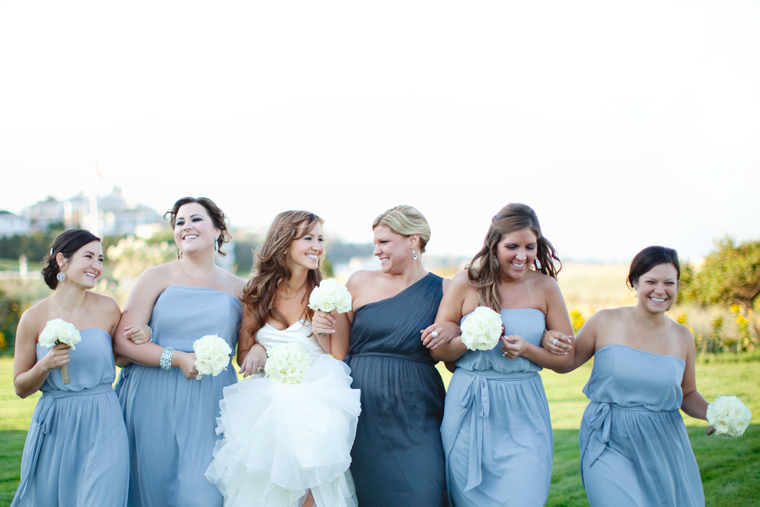 Bridesmaids in blue celebrate with bride outdoors