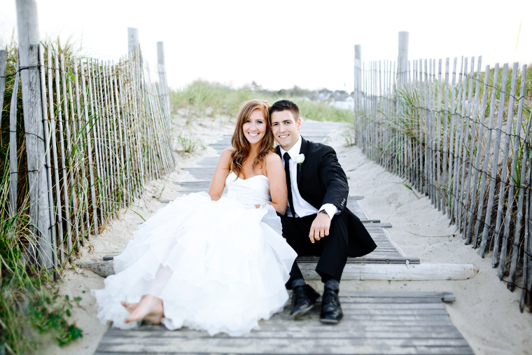 Bride and groom sitting on beach boardwalk wedding photo