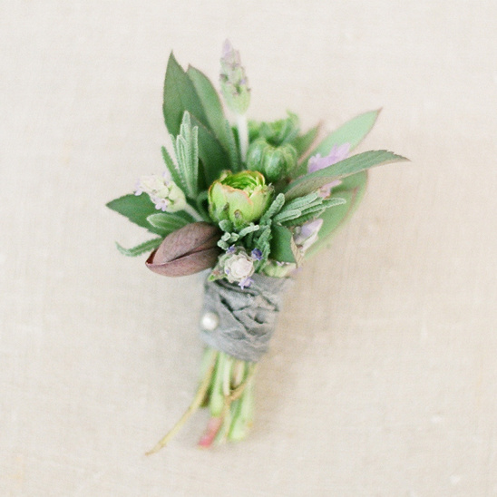 Delicate green floral boutonniere tied with gray ribbon