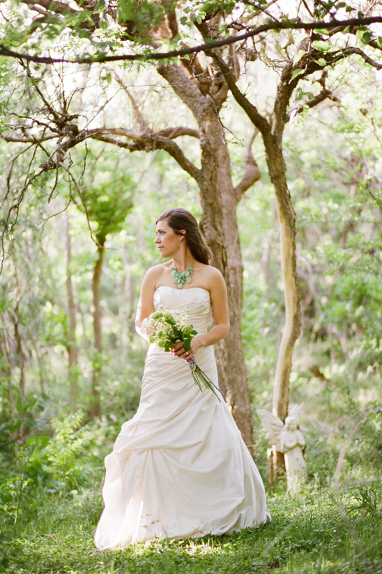 Bride in white dress in a sun dappled forest scene