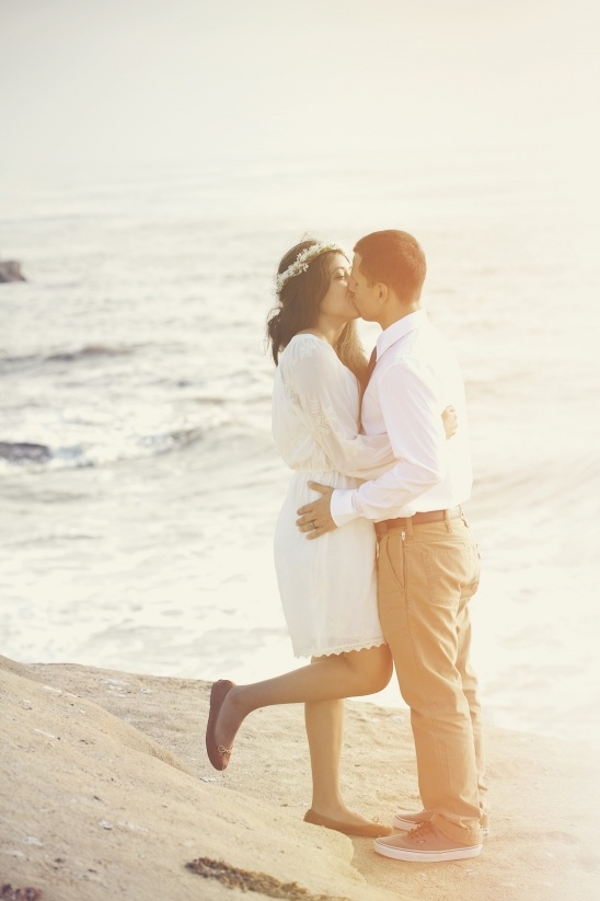 Couple kissing passionately on the beach at sunset, happy romance