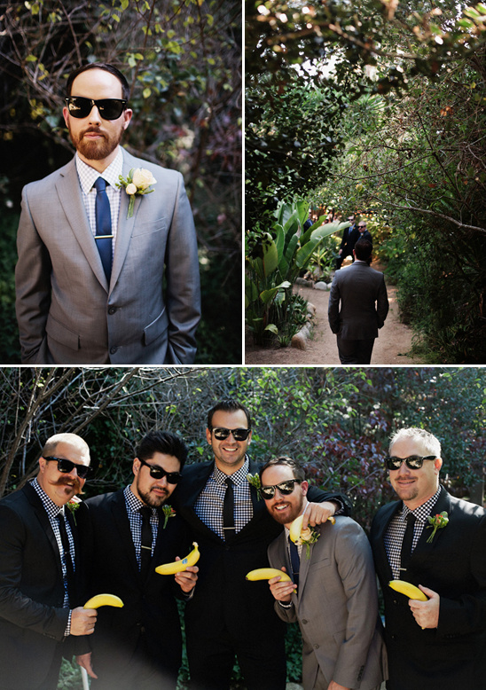 Groom and groomsmen in suits, holding bananas