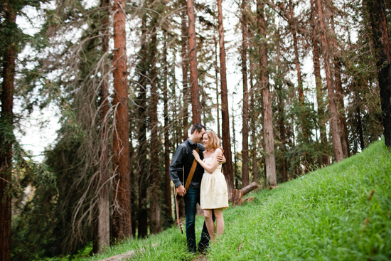 Couple embraces in a forest of tall trees, a moment of love