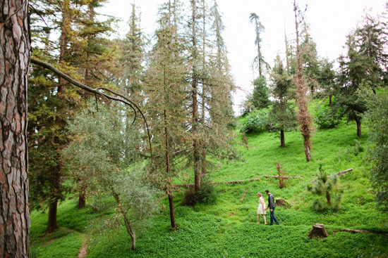 Couple walking through a lush green forest