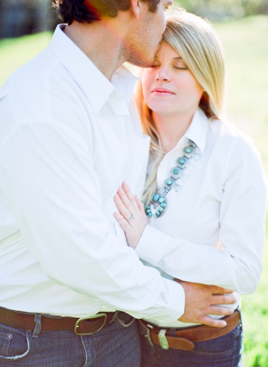 Romantic couple embracing outdoors, man kissing woman's forehead