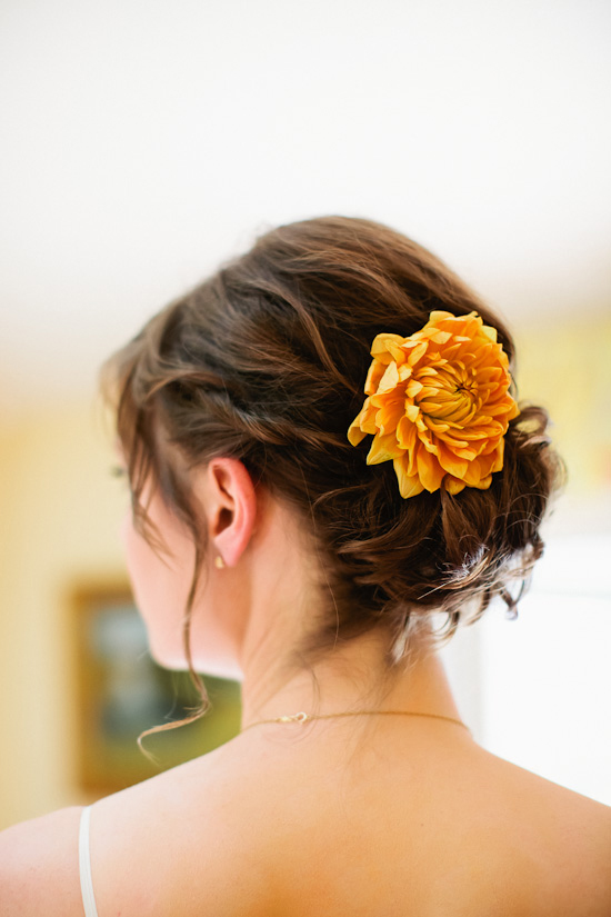 Bridal updo with orange flower hair accessory