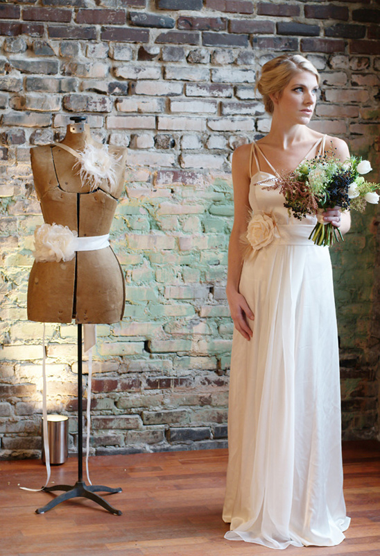 Woman in cream wedding dress, brick wall background