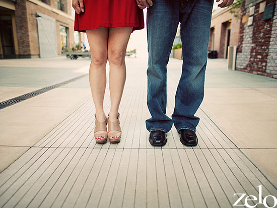 Couple holding hands in casual attire on a city walkway