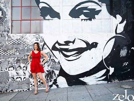 Woman in red dress poses by a stunning black and white mural