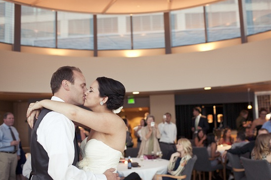 Bride and groom share a tender kiss during their wedding reception