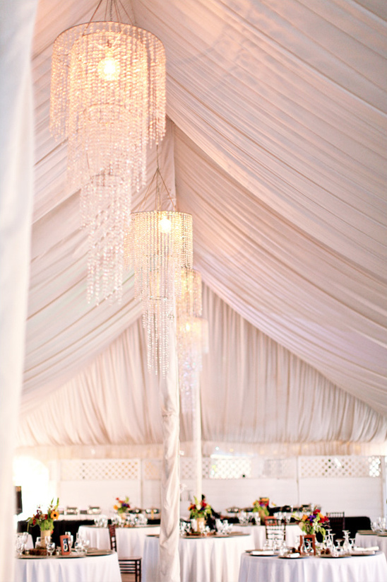 Elegant beaded chandeliers adorn wedding reception tent