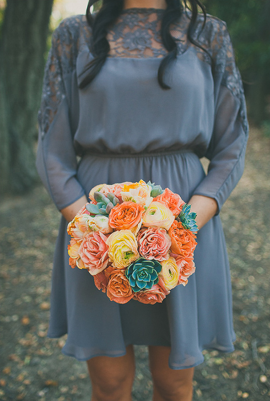 Woman in grey dress holding colorful flower bouquet