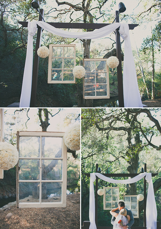 Outdoor wedding altar with vintage windows and white fabric