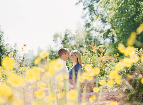 Couple in love embrace in a sunny field of yellow flowers