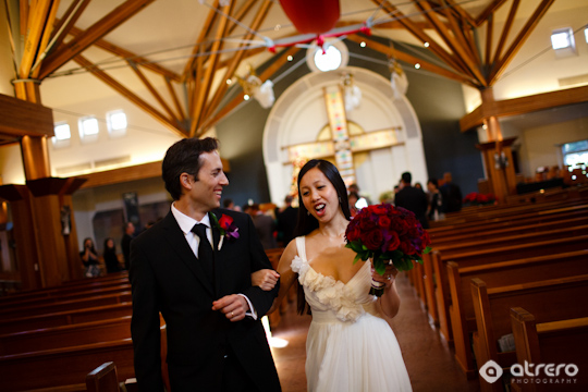 Happy couple celebrates their wedding inside a church, smiles are shown