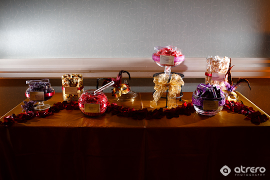 A dessert table with various candies in elegant glass jars on display