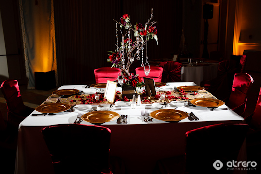 Elegant wedding table setting with red roses and gold plates