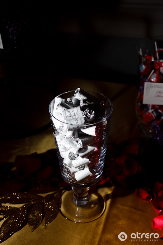Elegant glass filled with wrapped candies on a golden table