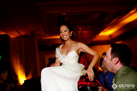 Joyful bride being lifted up at her wedding reception