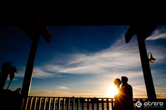 Couple silhouette kissing against the stunning sunset sky