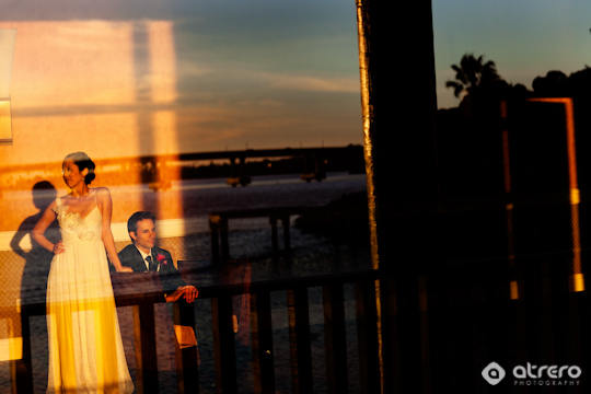 Wedding couple enjoying the sunset, reflected in window