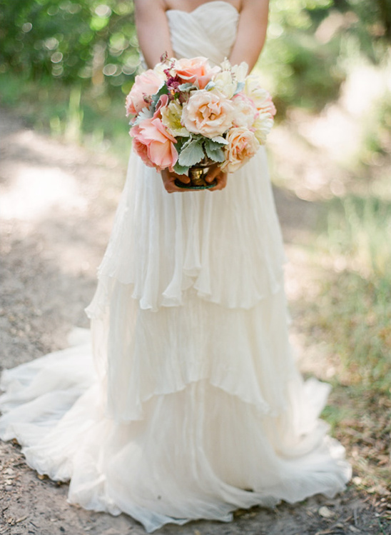 Bride holding a beautiful peach and ivory wedding bouquet