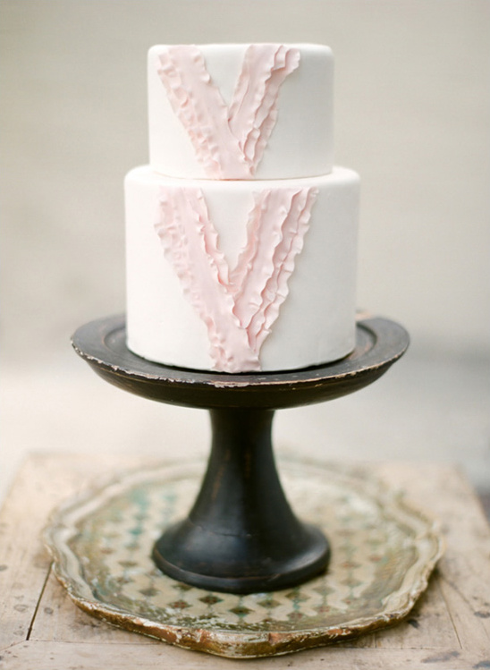 Elegant two-tiered wedding cake with pink ruffles