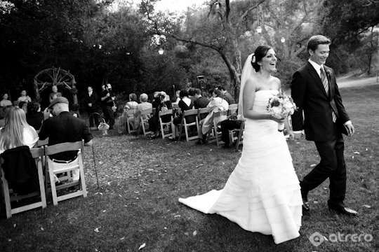 Bride and groom walking happily after their outdoor wedding ceremony