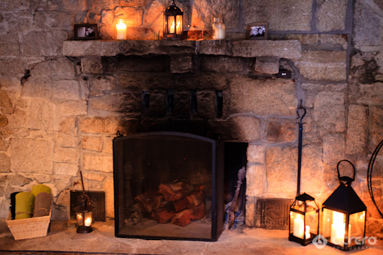 Cozy stone fireplace with burning wood and lanterns