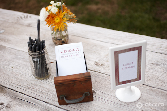 Wedding guest book and flower centerpiece on wooden table