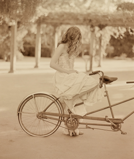 Woman in dress sitting on tandem bicycle