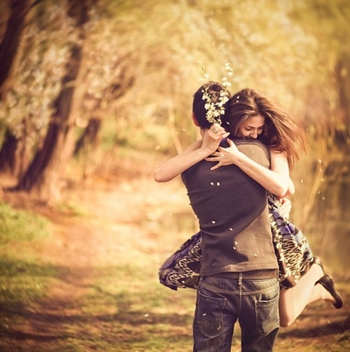 Couple embracing in a loving hug amidst a scenic outdoor setting