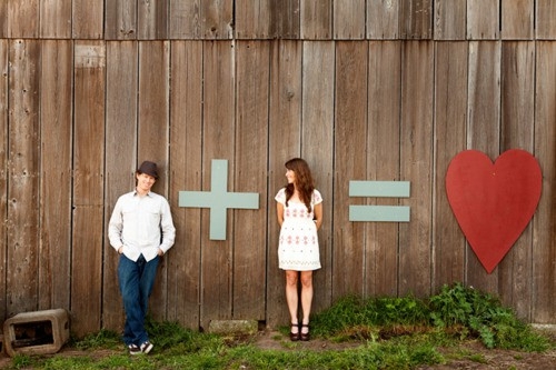 Couple equals love with a creative plus sign equation on a wall