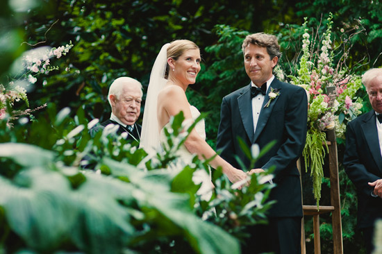 Happy couple at outdoor wedding ceremony with officiant