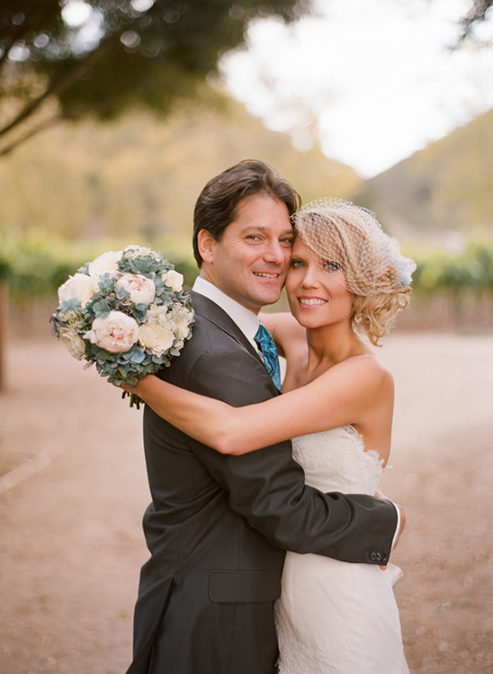 Happy bride and groom embrace at their outdoor wedding