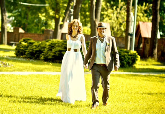 Happy couple walking in park on wedding day