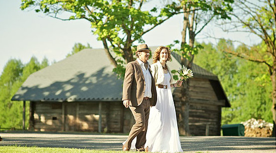 Happy couple walking towards rustic wedding venue