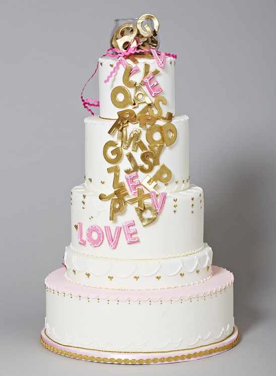 Elegant four-tier wedding cake with gold and pink letters