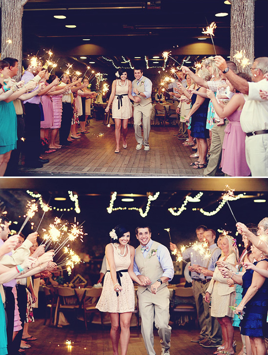 Happy couple exits wedding sparklers fly
