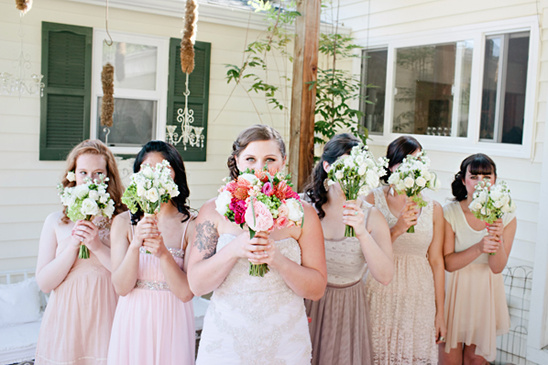 Bridesmaids hide behind bouquets of flowers