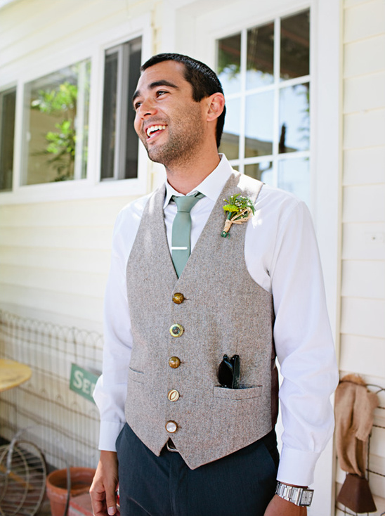 Smiling groom in beige vest and green tie, outdoor wedding