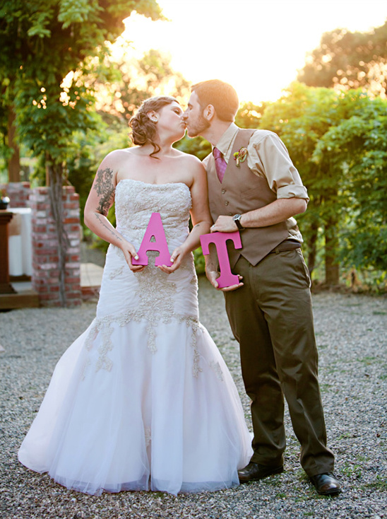 Bride and groom kissing, holding A & T wedding letters