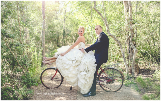 Bride and groom share a playful moment on a bicycle in a park