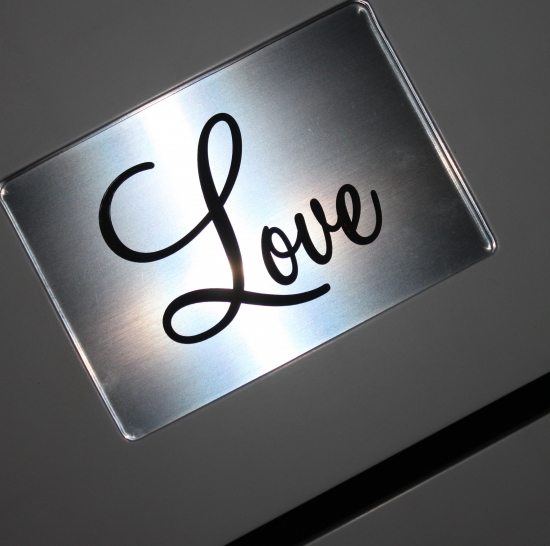 Metal sign with the word love in elegant calligraphy