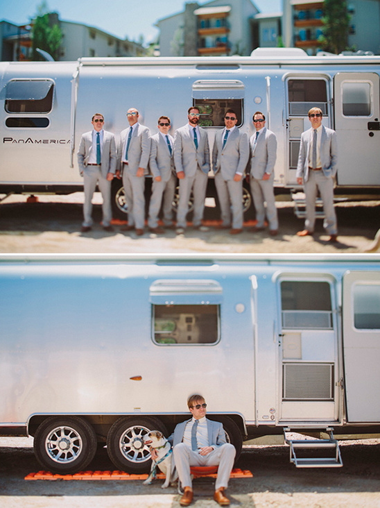 Groomsmen pose by a vintage Airstream, dog relaxes with groom
