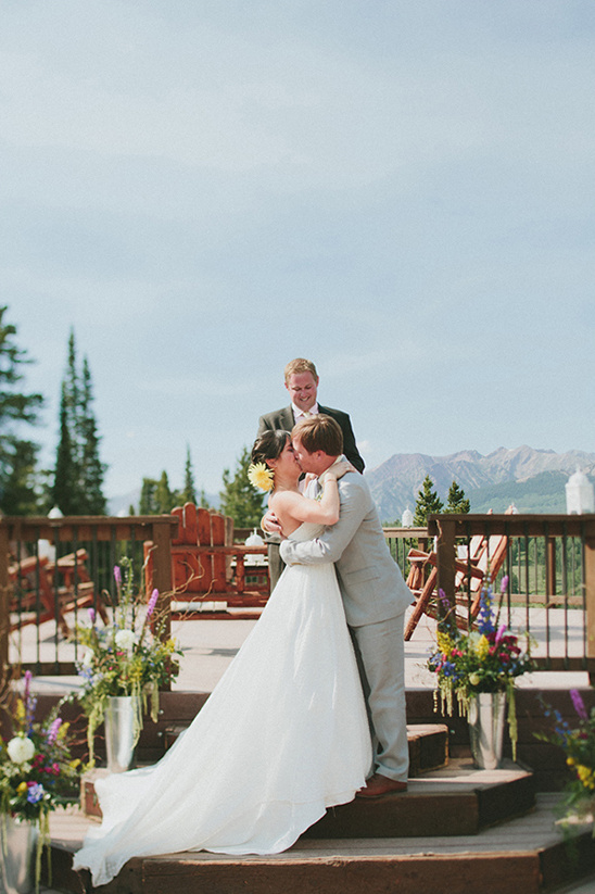 Bride and groom share a kiss during their outdoor wedding ceremony