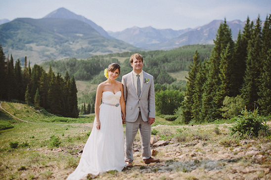 Bride and groom in wedding attire with stunning mountain backdrop