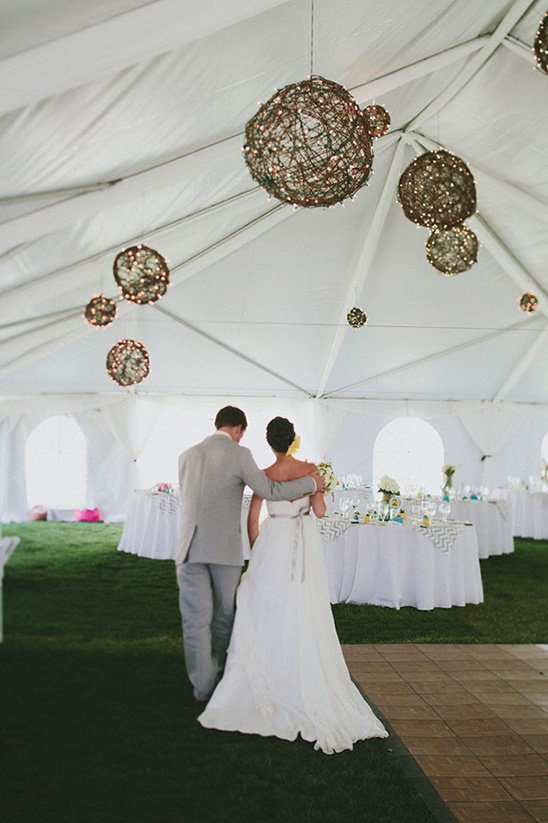 Bride and groom walking into wedding reception tent