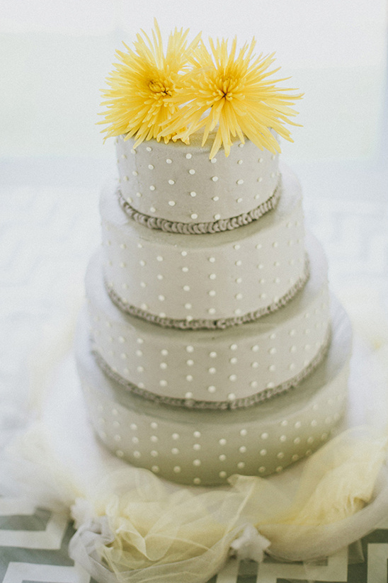 Elegant polka dot wedding cake decorated with yellow flowers