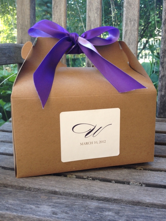 Gift box tied with purple ribbon on wooden table